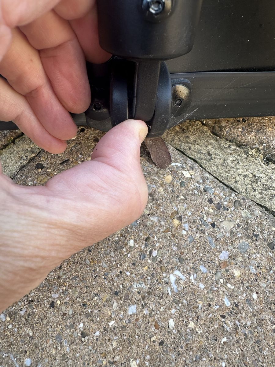 Thumb and finger gently prising apart the two sides of the clip at the bottom of the back leg